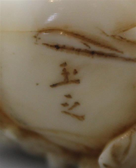 A Japanese ivory okimono of a farmer cutting a large turnip, signed Gyokushi, late 19th / early 20th century, 7cm, slight restorations